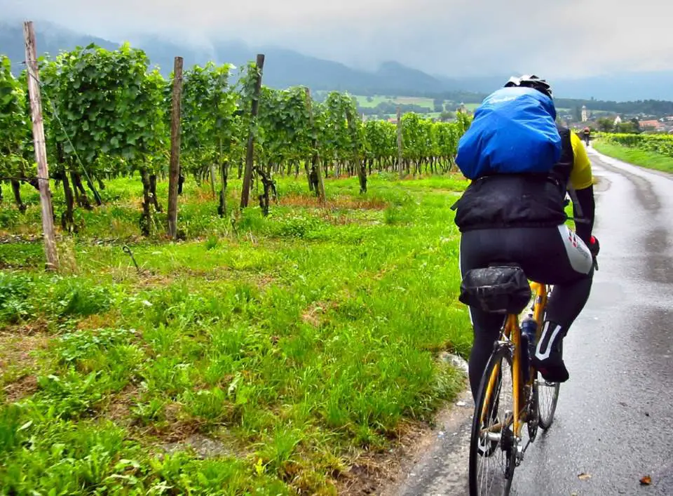 Tips for a Cycling Holiday in New Zealand - Cyclist riding in the rain with a backpack