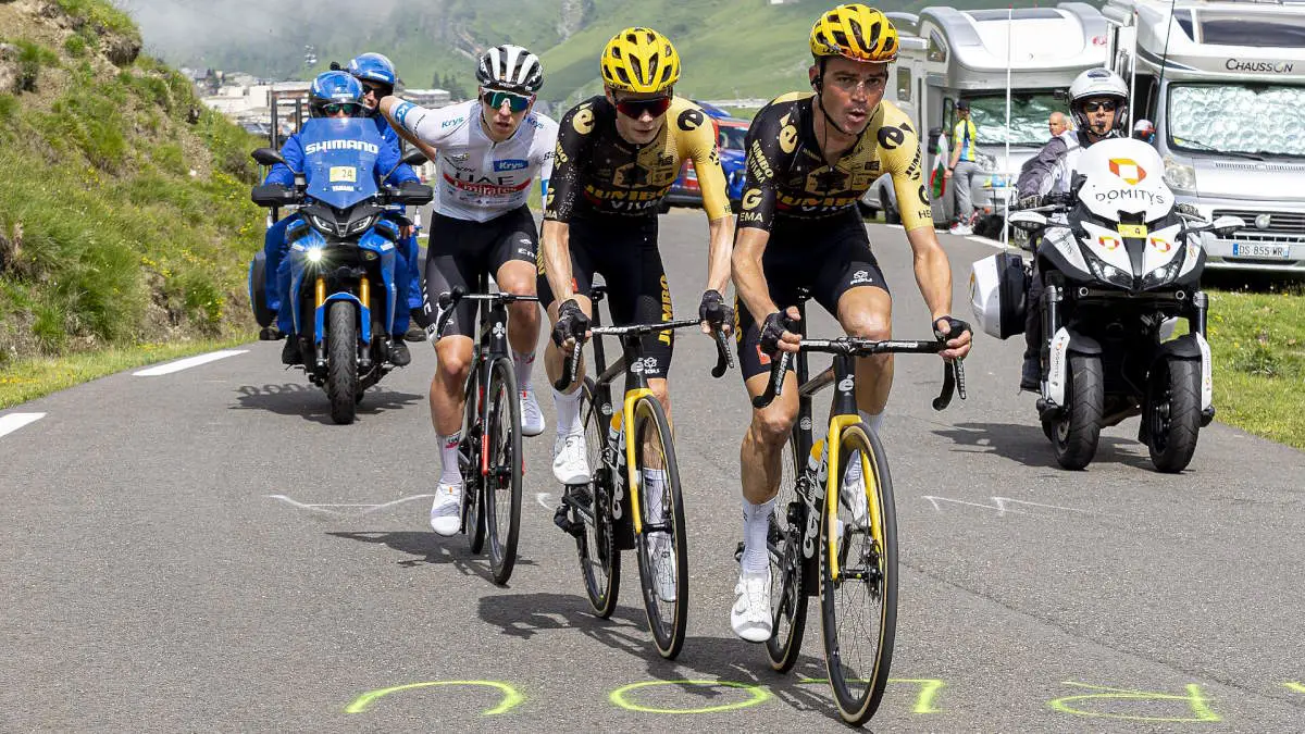 Sepp Kuss riding as a domestique in support of Jonas Vingegaard at the 2023 Tour de France, with Tadej Pogačar on Vingegaard's wheel.